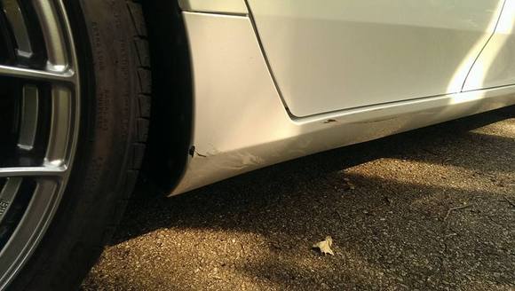 As I was pulling out from the grass parking spot and turning right I didn't see the metal charcoal bin laying on its side and this happened.  Fortunately the door and rim is fine...I was pretty bummed, but it can be fixed (girl who won't park the car under a pine tree)