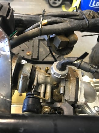 The back left is the fuel inlet.  Once again you can see that port near the throttle cable which I am wondering if it goes to that emissions box.