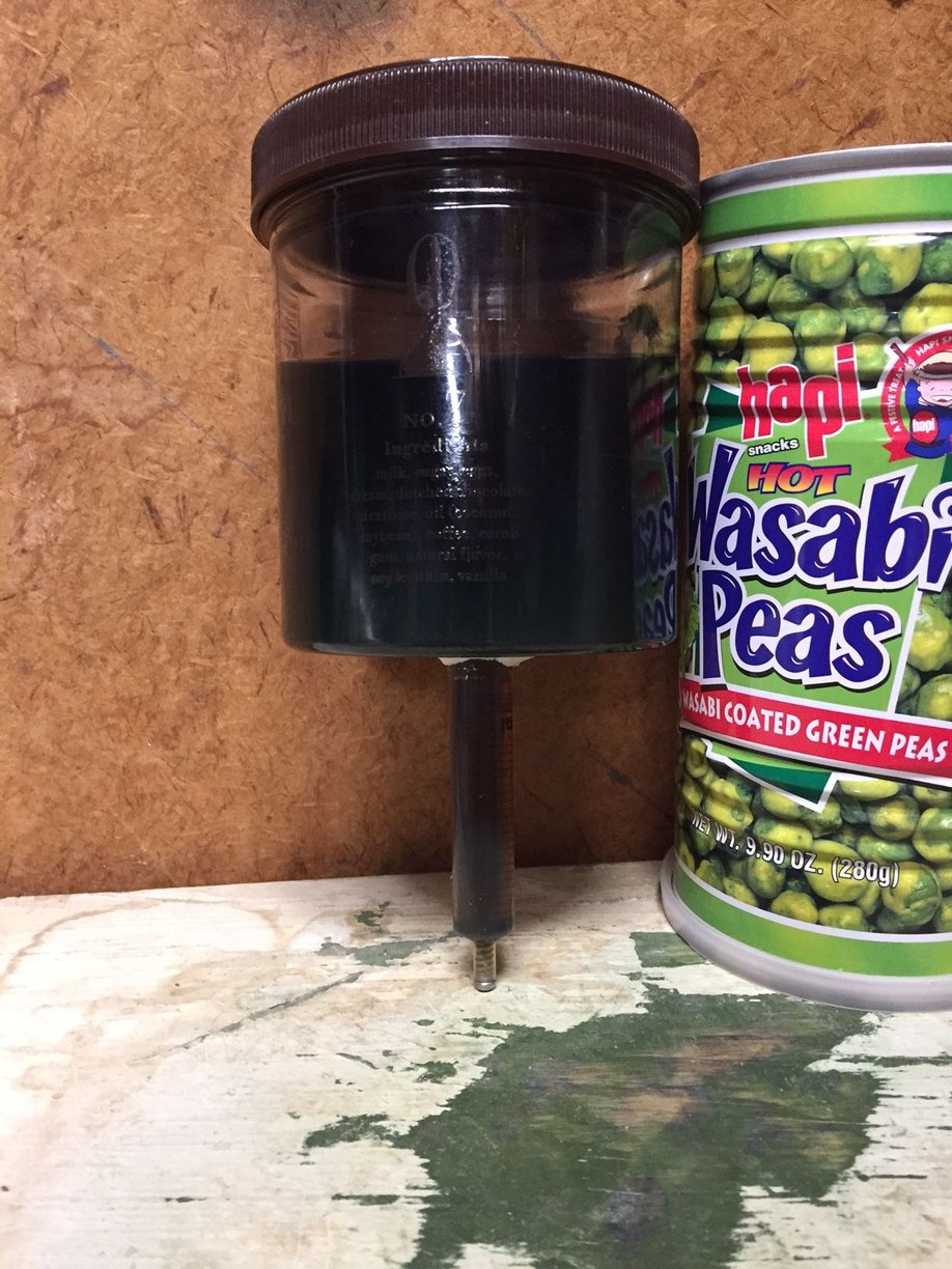 A plastic syringe attached (epoxy) to the bottom of an ice cream jar accommodates the axle.