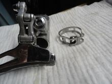 The bolt on the original was about 1/2" in length and screwed into the band and acted as a post for the derailleur body.  The fine thread of a Campy pivot bolt for the cage of a Record RD is a perfect fit, so the bolts must somehow exist.  I just want to find one.  