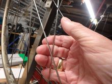Stressing the spokes by using the fingers and the heel of the thumb and working both sides of the wheel around a couple  of times.  I am showing one hand cause I gotta hold the camera with the other.