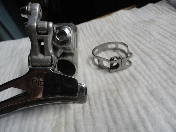 The bolt on the original was about 1/2" in length and screwed into the band and acted as a post for the derailleur body.  The fine thread of a Campy pivot bolt for the cage of a Record RD is a perfect fit, so the bolts must somehow exist.  I just want to find one.  