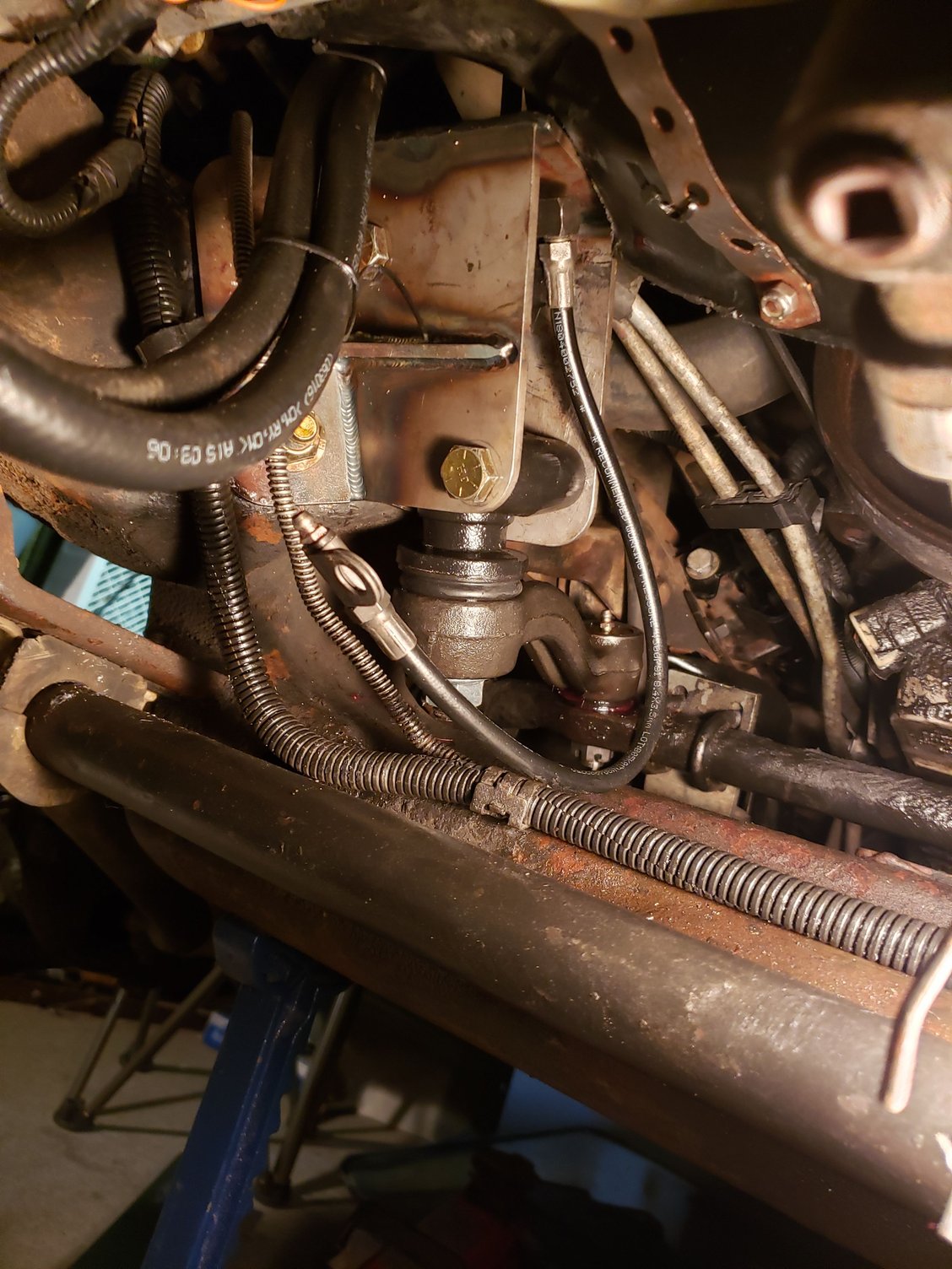 The idler arm bracket and upgraded idler arm parts installed. The pair of hoses on the upper left are the line to the extra transmission cooler. 