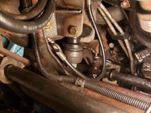 The idler arm bracket and upgraded idler arm parts installed. The pair of hoses on the upper left are the line to the extra transmission cooler. 