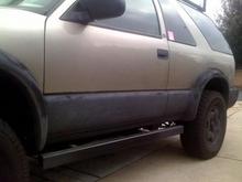 close up of 2x4 .250 square tubing custom made rock sliders and rino liner sprayed on the lower 12 inches of the truck.