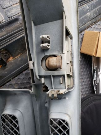 The plastic connector that behind the fog-light that holds the assembly to the grill. It is released by pinching the two together with your fingers.
