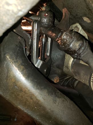 View looking over lower control arm showing the new position of the steering gear with the removal tool installed.