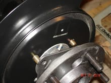 The spacer should fit behind the axle retaining plate.  If it's too thick, it will cause the retaining plate to bend; too thin and the bearing and seals will walk around under load and your wheels and tire could rub on the inner fenders when turning.