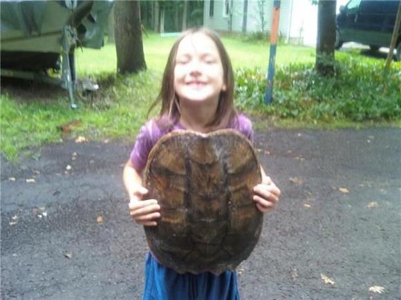 my daughter with a big turtle shell