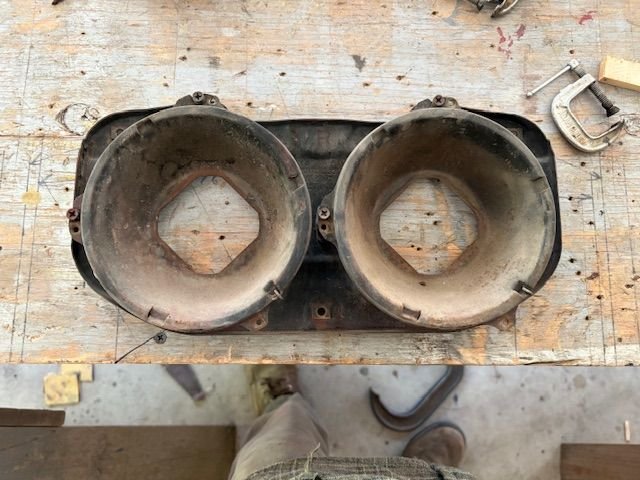 Trim rings off, revealing the light bulb holders.  They are held in place at two Adjuster screws and on retaining spring.  Grabbed the spring with a vice grip and it came up and off fairly well