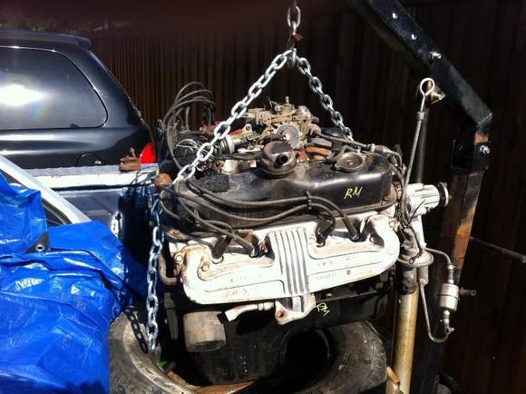 The not-so-powerful engine I purchased from a local salvage yard.  The best I can decipher from the numbers... it's a 1987 318, 4 bbl Rochester Quad sitting on top.