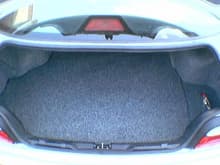 Trunk of 3 series with amp and sub protective cover, factory carpet went over top.