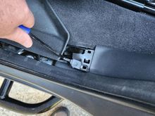 Pull the plastic sill cover atraight up and use a panel puller to release the plastic tab located under the cover 