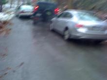 navigating a sheet of ice on a hill between two abadoned  honda accords.