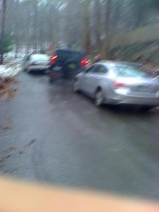 navigating a sheet of ice on a hill between two abadoned  honda accords.