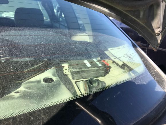 this is the view of the sending unit for the remote control, located on the rear deck on the passenger side.  The little tube is the trunk lid hinge and to the left is a speaker hole.  You could check under the deck cover to see if this is back there.  Maybe the wires were cut at one time.  