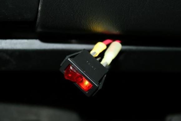Red toggle switch under the lower dash panel.