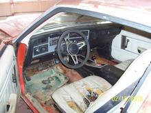 Ragged white interior. I am going back with black. Notice the patch in the floor. It is a piece of a fender from a Dodge Shadow.