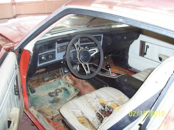 Ragged white interior. I am going back with black. Notice the patch in the floor. It is a piece of a fender from a Dodge Shadow.