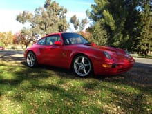 1995 C2 manual Guards Red in the park with fall leaves.
