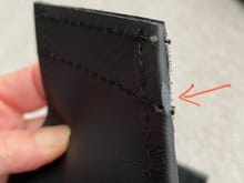 Arrow points to tiny defect in leather on leading edge of second (smaller) piece located at the bottom.  Will not be visible once installed.