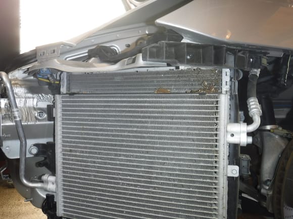 Left AC condenser.  Note debris at top of radiator behind it.