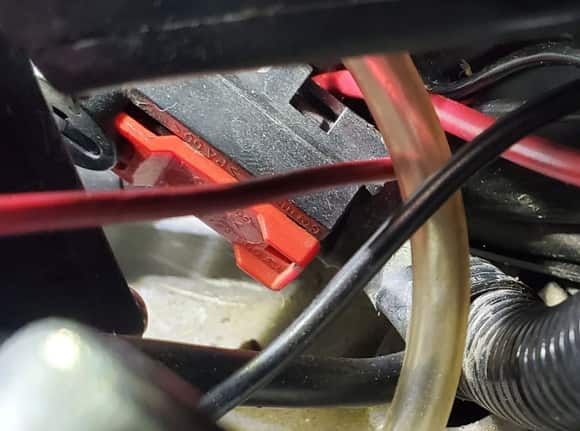 This is the connection in the front trunk.  Slide the red clip out and then pull the connector off the post.