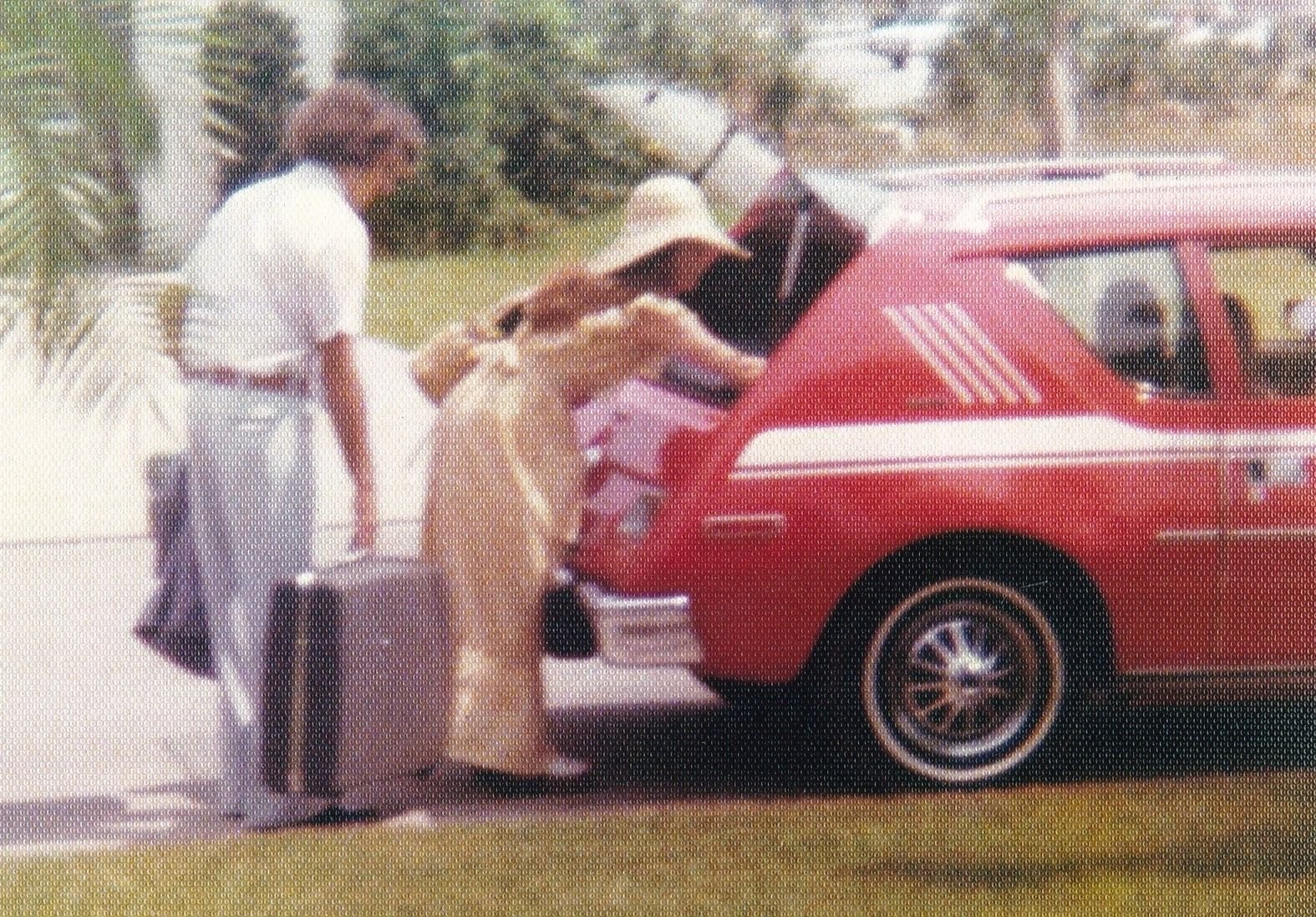 Yours truly (with lots of hair) and wife going on our honeymoon in her 1975 AMC Gremlin in 1977.