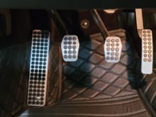 Alloy dead pedal cover, fastened over the leather floor mat. 
