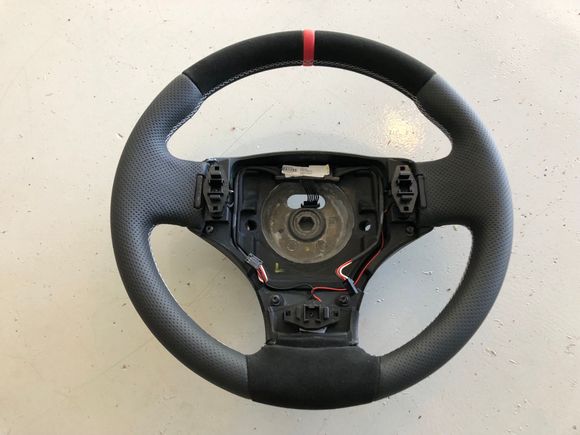 He was able to make it about 1cm thicker in diameter.  Alcantara top and bottom, red leather centering strips and silver stitching to match my interior...