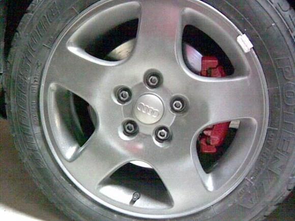 Closeup of the wheels on the car. The red tint on the spokes is from a box that was behind me. Need some tire shine desperately in this pic.