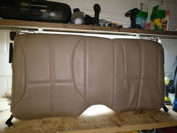 Here is the upper back seat removed from my car. The vinyl/carpet cover is one piece. Once you remove the latching hardware from the seat,