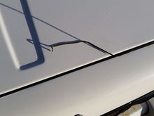 I shaped my coat hanger on the hood to get a reference of where the bends needed to be. The hook on mine bends up then toward me then back down. Make the hook just big enough to go over the latch rod. My first attempt it was too big and there wasn't enough clearance between the hood and the rod to get the hook through. I apologize for the shadows if they make it difficult to see.