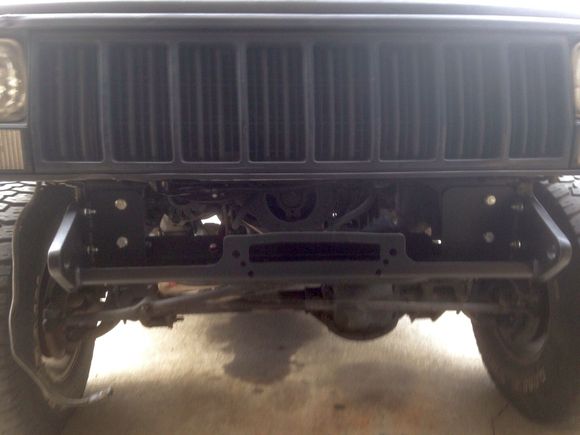 I had to cutout most of the front cross member to fit the winch under the grill/radiator. Used a cut down Harbor freight winch moun as a base and welded mounts to it. It is secured in 19 (!) locations to the original bumper mounts, steering box bolts, swaybar mounts and to the factory tow points near the springs.