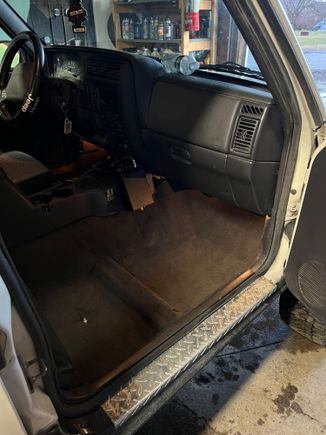 Wet floorboard update: carpet is dry and back in place. I did some more leak tests with the hood closed and no more water has gotten in! 