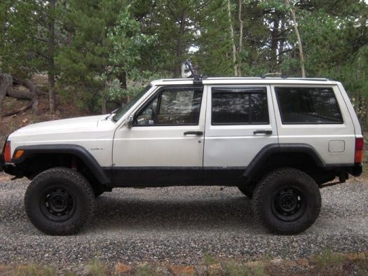 JRC Offroad light bar on top with four HID's (two are 6000K, two are 4300K) powered by 55w ballasts that sit between the headliner and cieling.  In this pic, you can see the rear doors that I've replaced and are a different white.  I now have power windows in the back, crank windows in the front.