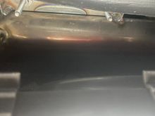 Looking up through the glove box opening you will see 2 studs. Remove the nuts from each stud using the 11 mm socket and ratchet.