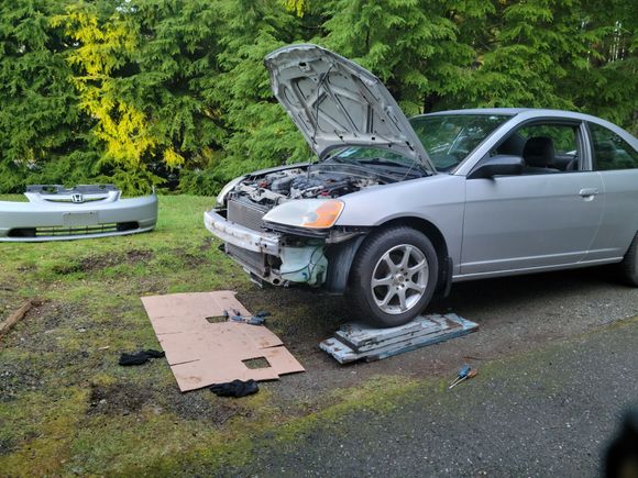 Removed the front bumper cover in order to get at the headlamp assemblies. We bought replacements, because the old ones had turned yellow and a bit foggy.