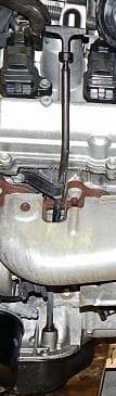 Image depicting oil dipstick tube mounting ear and bolt.