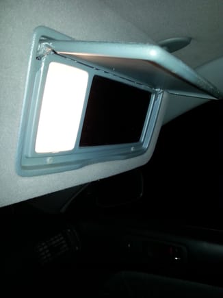 The passenger sun visor shown open....for incandescent, the lighting is quite good, however, head on there is a glaring hot spot and lack of uniformity...to my eye the sides, and  especially the corners appear dim....so room for improvement....
