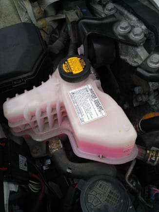 This is invertor coolant reservoir.there is label also to confirm that.
I did this in my friend garage .raise the car and locate drain plug for invertor coolant.