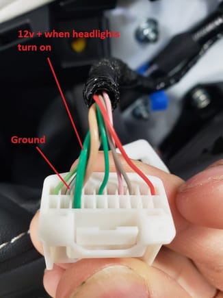 The thicker green wire on the side of the connector is 12v + when the headlights are turned on.