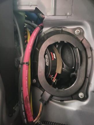 There is a small hole through the bulkhead near the right subwoofer.  There is a sound insulation piece that needs to come out, but it fits back in when done.  