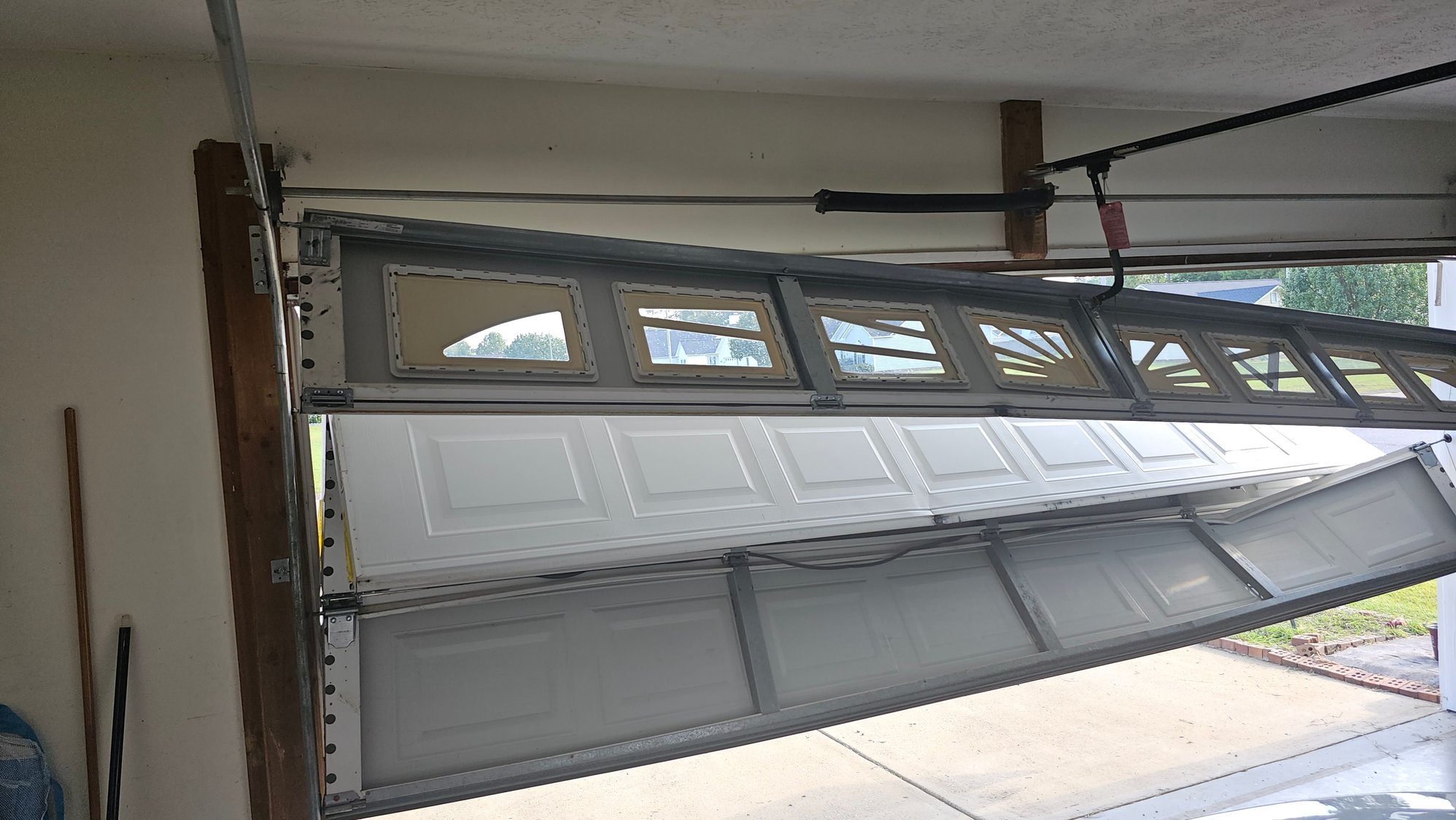 Older type plastic riveted hinge garage door folded on itself
