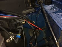 Location of the grommet on the driver's side.
The red/black cable is the power cable to the radio.