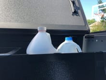 Standard washer fluid doesn't fit beneath tonneau but normal milk jug does.  I'll transfer into the milk jug and keep one in the Bakbox, especially in the winter months.