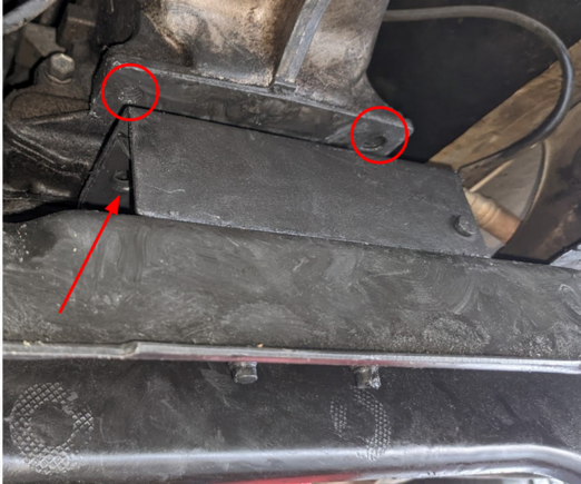 The two threaded bolts are circled in red. Only one of the thru holes in the transmission mount is visible (red arrow).
