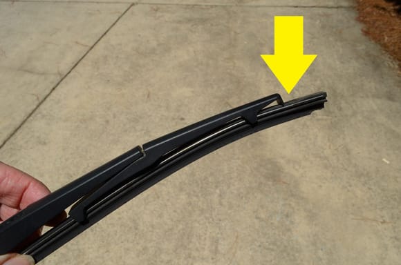 Pull blade tip and lift it out of the wiper arm to clear it of the metal stop at the end.