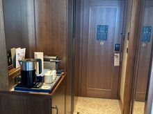 Look into the entry vestibule, left the minibar, kettle and Nespresso coffee machine and closet, right the bathroom