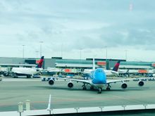 KLM 747 Framed by Delta tails at Amsterdam Schiphol.